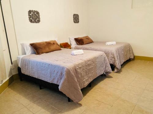 two beds sitting in a room withermottermott at Villas Cairo in Guatemala