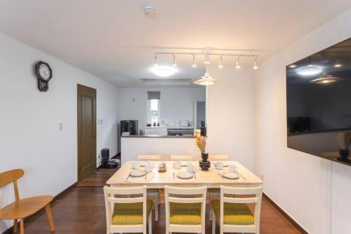 a dining room with a white table and chairs at Kamonoya Toya House in Lake Toya