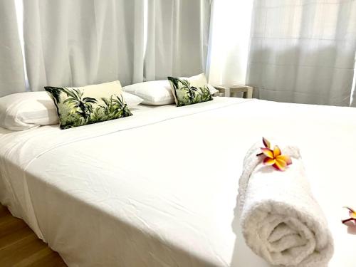 a white bed with a towel on top of it at Heitiare lodge in Paea