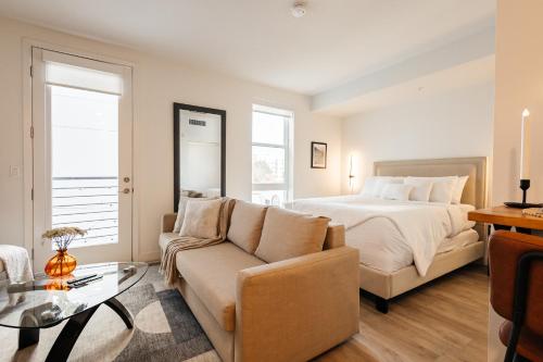 a bedroom with a bed and a couch and a table at Elegant Apartment in the Heart of Hollywood in Los Angeles