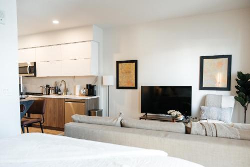 a living room with a couch and a flat screen tv at Elegant Apartment in the Heart of Hollywood in Los Angeles