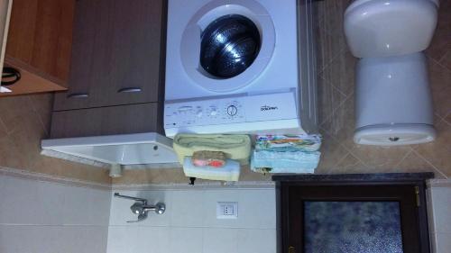 a kitchen with a washing machine and a washer at Etna Sun Guest House in Mascali