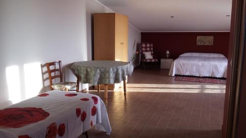 a bedroom with two beds and a table in a room at Etna Sun Guest House in Mascali