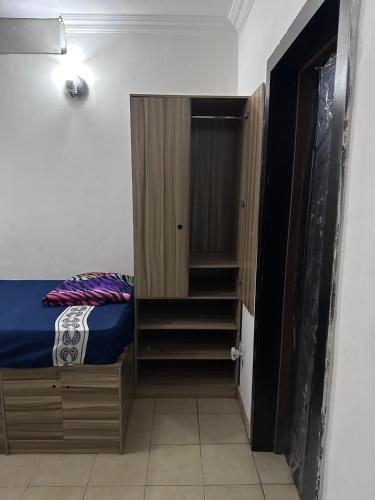 1 dormitorio con 1 cama y armario pequeño en Jacob Mews Estate, en Lagos