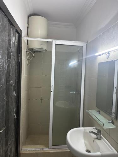 y baño con ducha acristalada y lavamanos. en Jacob Mews Estate, en Lagos