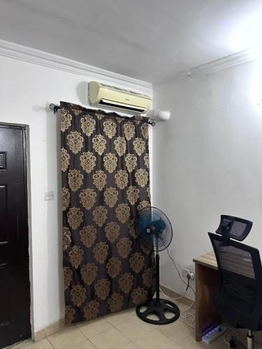 Habitación con una pared con cortina y ventilador en Jacob Mews Estate, en Lagos