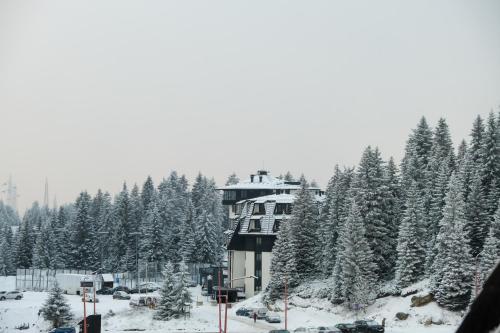 a building with snow covered trees in front of it at Apartments Pavle in Kopaonik
