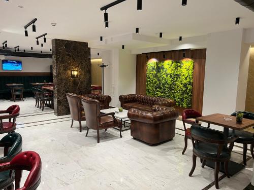 a restaurant with leather furniture and a green wall at Queen of Zlatibor in Zlatibor