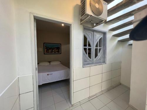 a small room with a bed and a window at Bela Casa Praia dos Carneiros Condominio Beira Mar Seg 24hrs FRENTE PISCINAS NATURAIS!!! in Praia dos Carneiros