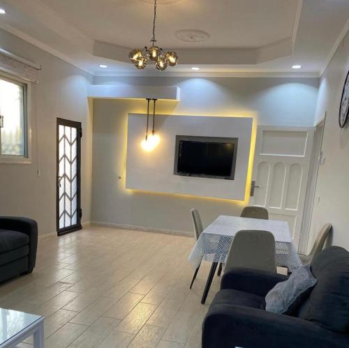 uma sala de estar com uma mesa e uma televisão na parede em فيلا 109 الطائف الشفا em Al Shafa
