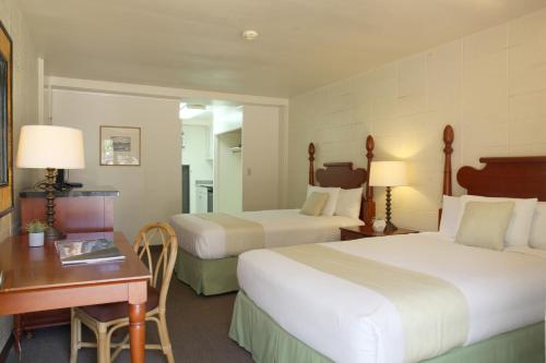 Habitación de hotel con 2 camas y escritorio en By the Beach Waikiki Heritage Hotel Honalulu, en Honolulu