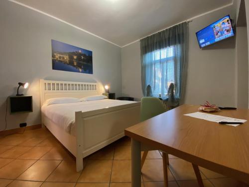 Schlafzimmer mit einem Bett, einem Schreibtisch und einem Tisch in der Unterkunft DOMUS Hotel in Caselle Torinese