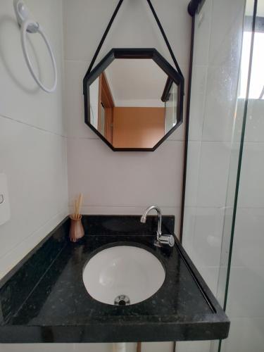 a bathroom with a sink and a mirror on the wall at Residence Unno - Carapibús - PB / O paraíso que você procura esta aqui. in Jacumã