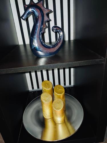 a plate with five candles on a shelf with a vase at City Apartment Paderborn Apartment 6 in Paderborn