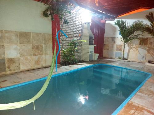 a swimming pool with a water hose in a backyard at Casa Boa Venttura Guajiru 3 quartos com ar e piscina in Trairi