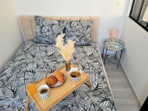 Una cama con una mesa con una bandeja de comida. en Splendide Appartement Proche Paris & Orly, en Chevilly-Larue