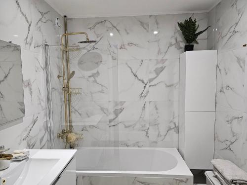 y baño blanco con bañera y ducha. en Splendide Appartement Proche Paris & Orly, en Chevilly-Larue