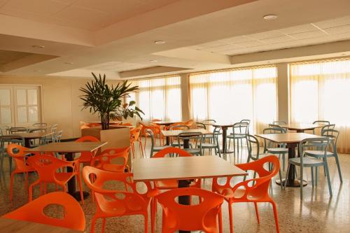 a restaurant with tables and chairs and windows at Hotel Gimaura in Ríohacha