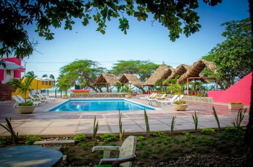 a pool at a resort with chairs and tables at Hotel Gimaura in Ríohacha