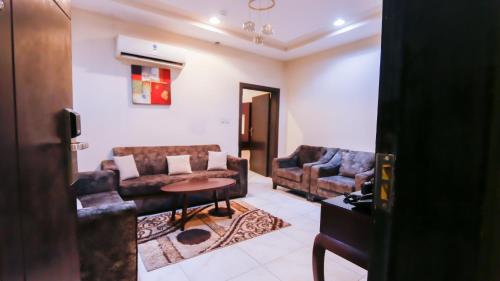 a living room with two couches and a table at Ru'a Al Qunfudhah Furnished Units in Al Qunfudhah