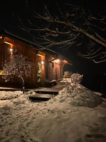 a house covered in snow at night with lights at AISLAMIENTO, Luxus faház in Zalaegerszeg