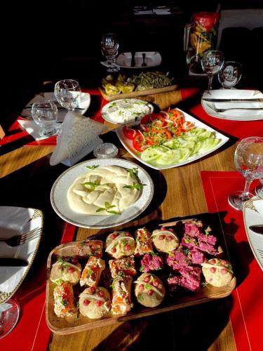 a wooden table with plates of food on it at Zanduri House in Utskheri