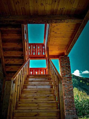 a wooden staircase leading up to a wooden house at Zanduri House in Utskheri