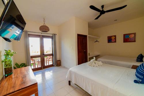 a bedroom with two beds and a flat screen tv at Hotel San Vicente in Playa del Carmen