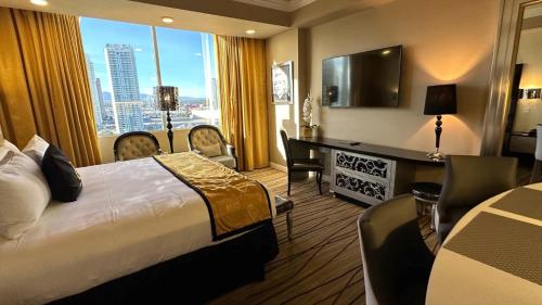a hotel room with a bed and a desk with a window at Westgate Las Vegas Resort & Casino located in the heart of Las Vegas Nevada 5Minutes Walk to Las Vegas Convention Center in Las Vegas