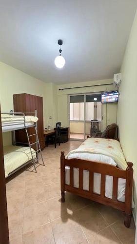 1 dormitorio con litera y escritorio en Budget Beach Apartment 35% Discount, en Durrës