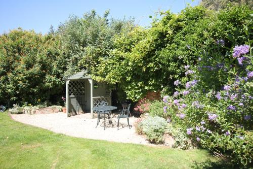 a garden with a table and chairs under a gazebo at The Old House in Nether Stowey