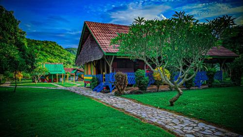 een huis met een groene tuin en een boom bij 4 Pohon - Les 4 Arbres in Pandang