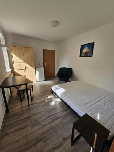 1 dormitorio con cama, mesa y escritorio en Privat Zimmer mit eigenem Bad, en Rostock
