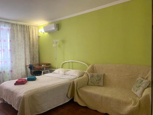 - une chambre avec un lit, un canapé et une fenêtre dans l'établissement Podil Apart Сковороди Kontraktova Ploscha, à Kiev