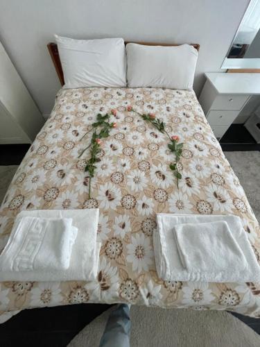 a bed with two white pillows and flowers on it at Mia Property - Two Mile Hill in Bristol