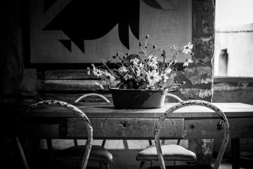a bucket of flowers sitting on a table with two chairs at Inter Artes Prestige House and Luxury Suite in Viterbo