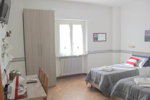 1 dormitorio con 2 camas, mesa y ventana en B&B Panorama d'Assisi en Santa Maria degli Angeli