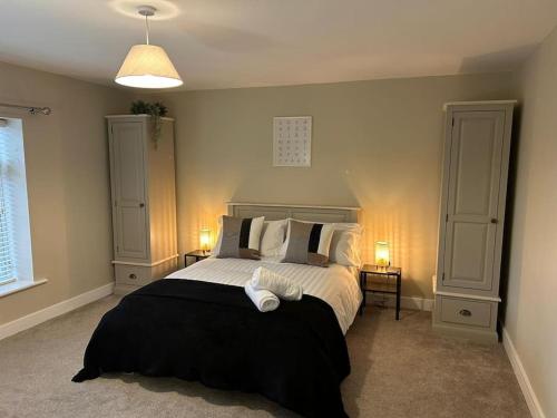 a bedroom with a large bed with two night stands at Modern Relaxing Apartment in Stoke on Trent