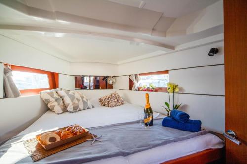 a bed in a boat with a bottle of wine at Barca a vela Kerama - Smart Wind in Naples