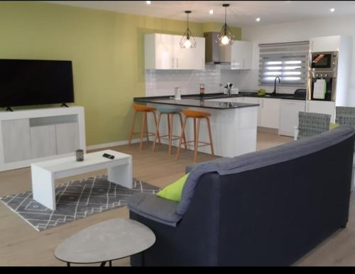 un soggiorno con divano blu e una cucina di spacious 2 bedroom holiday home torre villas d a Machico
