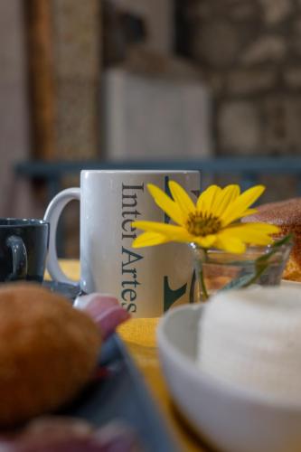 a coffee cup with a yellow flower on it at Inter Artes Prestige House and Luxury Suite in Viterbo