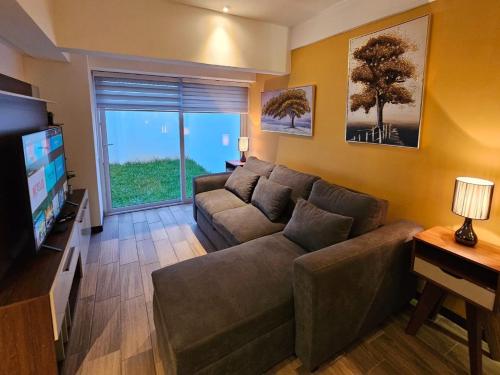 sala de estar con sofá y TV de pantalla plana en Torre Pamplona 102-Nuevo y Céntrico-Apartamento en Guatemala
