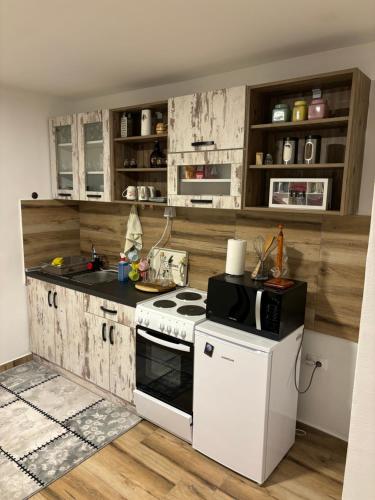 a kitchen with a white stove and a white refrigerator at Vujanac vikend kuća in Raška