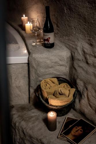 a bathroom with a bottle of wine and a candle at Inter Artes Prestige House and Luxury Suite in Viterbo