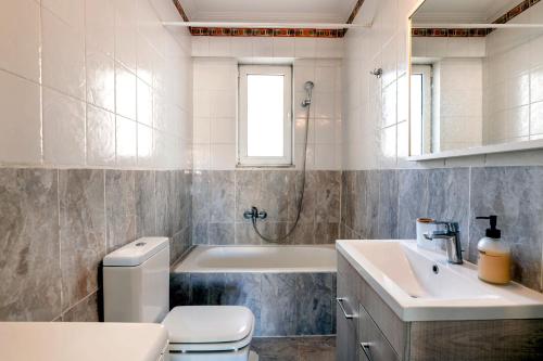 a bathroom with a toilet and a tub and a sink at Boutique52 Luxury Apartments in Athens
