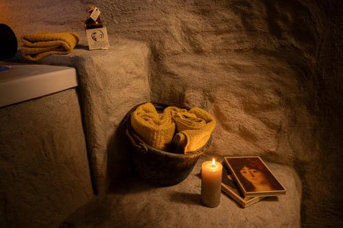 a candle and a picture and a picture next to a toilet at Inter Artes Prestige House and Luxury Suite in Viterbo