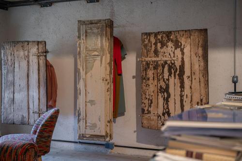 a room with two wooden doors and a chair at Inter Artes Prestige House and Luxury Suite in Viterbo