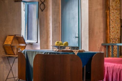 a table with a bowl of green apples on it at Inter Artes Prestige House and Luxury Suite in Viterbo