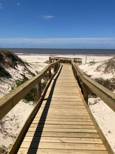 a wooden boardwalk leading to the beach at Mar 11 a 100 mtros del mar in Parque del Plata