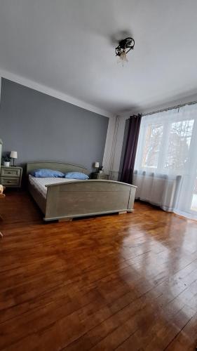 a bedroom with a bed and a wooden floor at AGAWA NOCLEGI in Tarnów